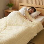 ผู้หญิงนอนหลับห่มผ้าห่ม Marshmallow อยู่บนที่นอน