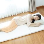 ผู้หญิงนอนบนที่นอนสุขภาพ แก้ปวดหลัง Kenko Mattress ลักษณะกางออกวางบนกับพื้น