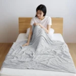 ผู้หญิงนั่งบนเตียงพร้อมลูบปลอกผ้าห่ม Tororon Melty Duvet Cover